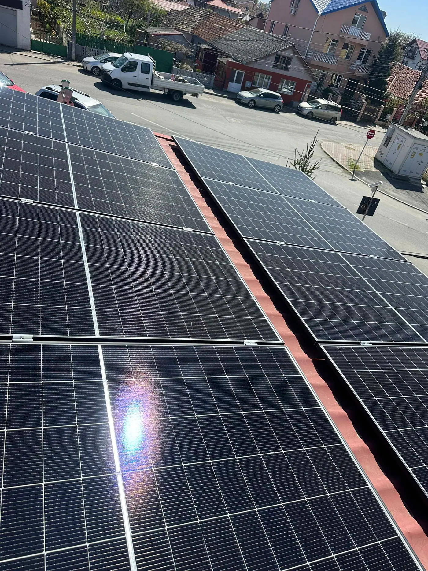 Panouri fotovoltaice pe un acoperiș, spre stradă