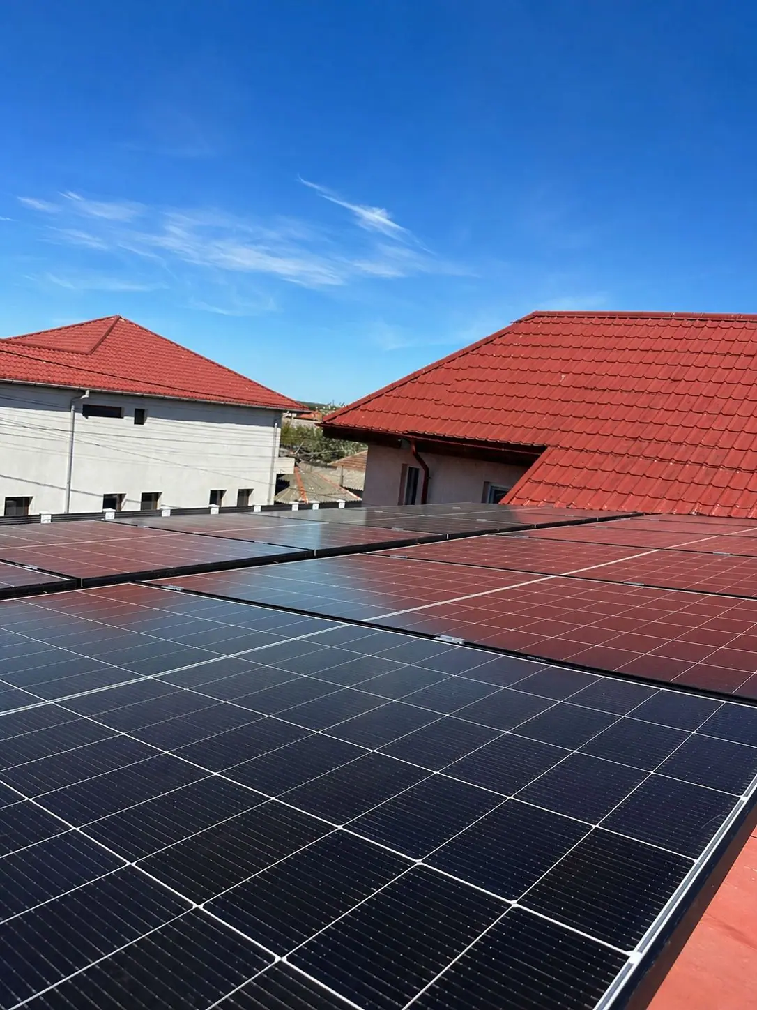 Panouri fotovoltaice pe un acoperiș din țiglă roșie