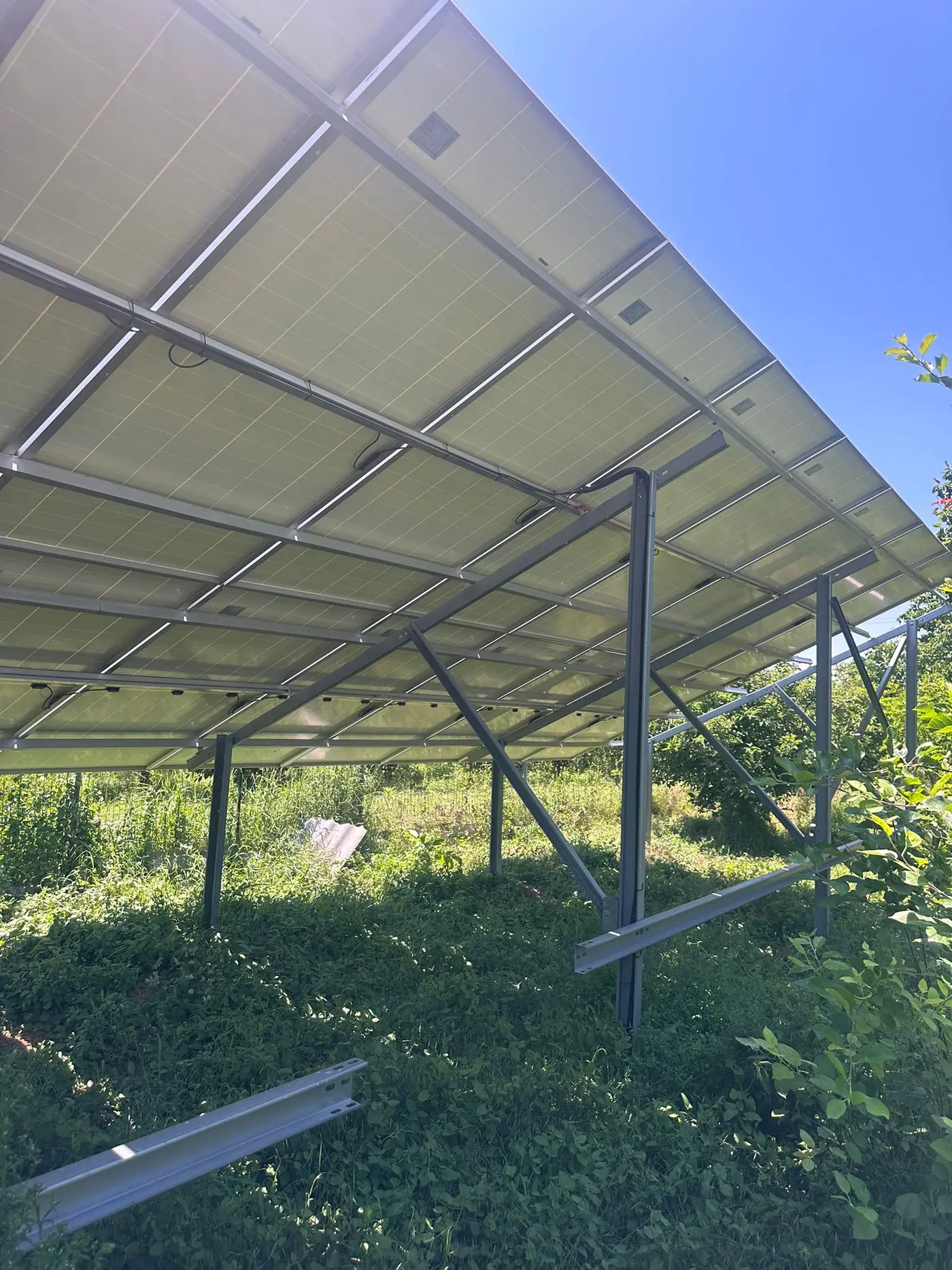 Structura metalică a unui sistem fotovoltaic la sol, văzută de dedesubt